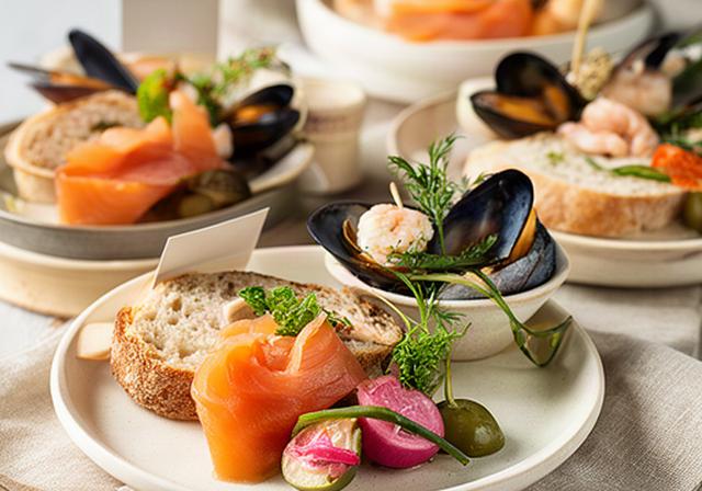 Porsjonerte sjømat-tapasstallerkner med røkt laks, blåskjell og små brødskiver